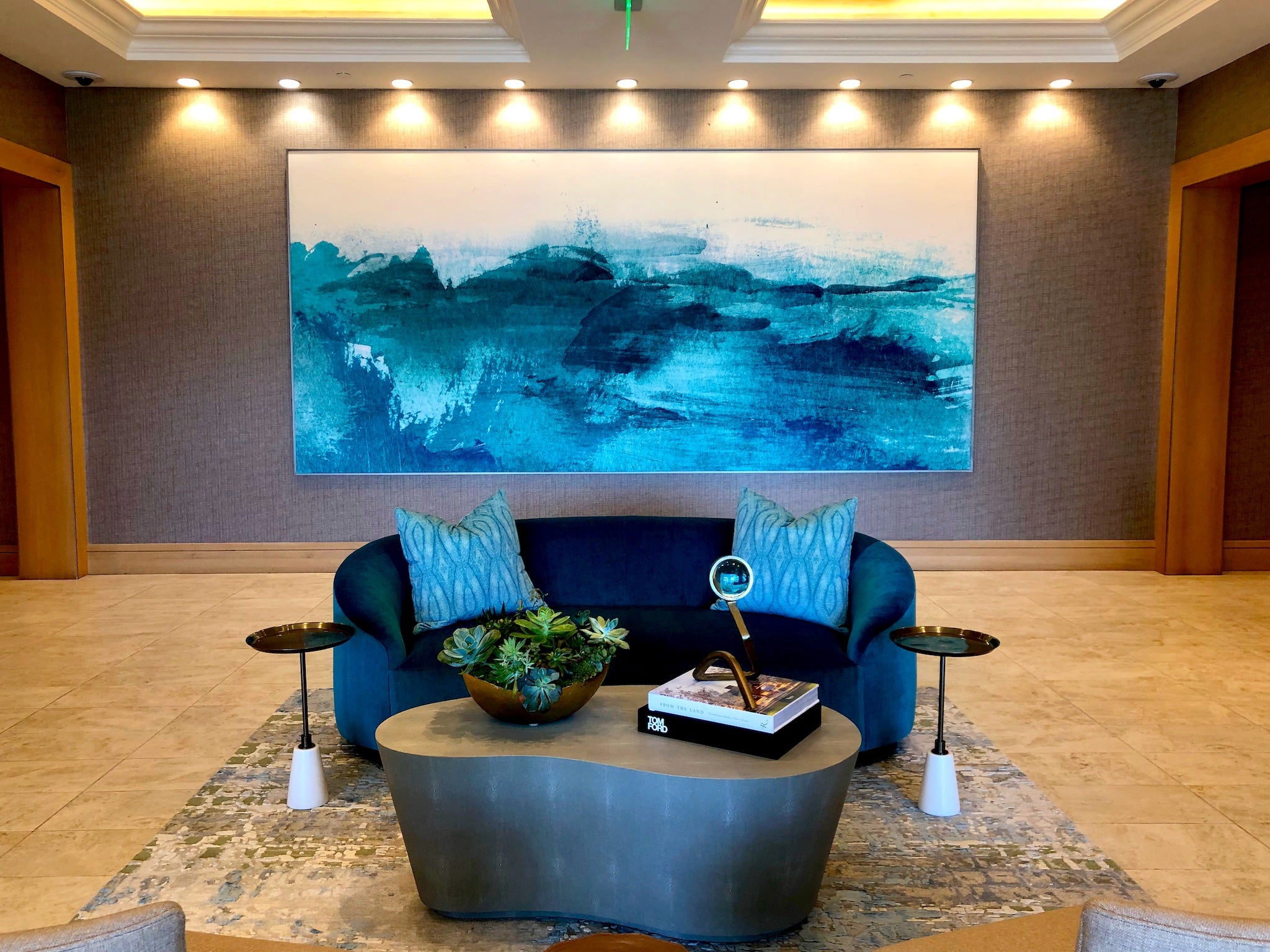 Upscale reception area at 1221 Avenue enhanced by WRAPPED Studio's custom oceanic artwork, capturing the serene energy of the sea with its vivid blue color palette.