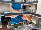 1641 Lincoln Apartments featuring an expansive, two-story hand-painted mural by WRAPPED Studio, with abstract oceanic shapes guiding tenants through the space.