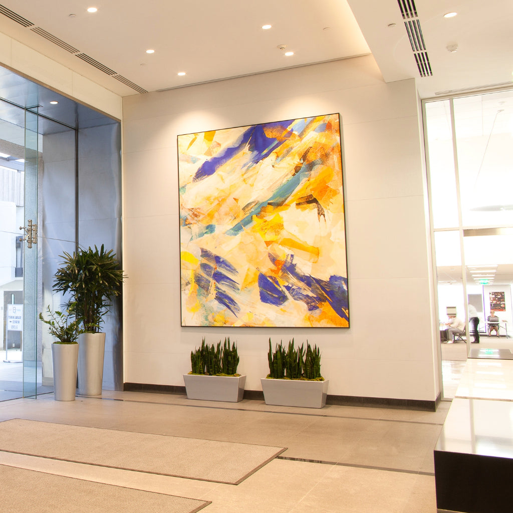 Bright and airy lobby of Colorado Office featuring a large yellow-toned abstract canvas by WRAPPED Studio, reflecting the building's upscale, modern vibe.