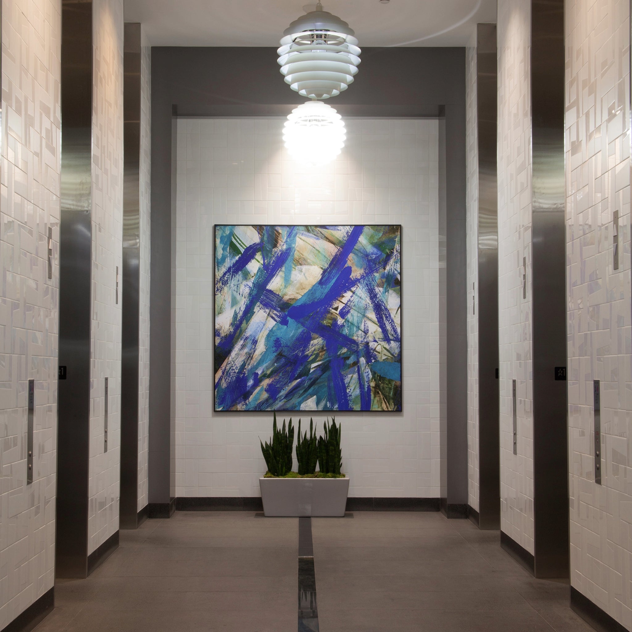 Elevator bank in office lobby enhanced by WRAPPED Studio's blue and violet abstract large-format canvas painting.