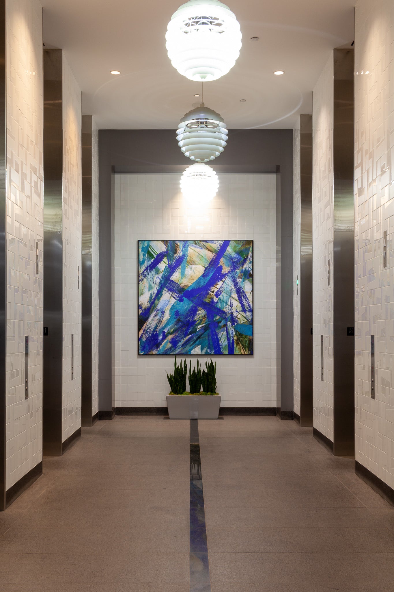 Elevator bank in office lobby enhanced by WRAPPED Studio's blue and violet abstract large-format canvas painting.
