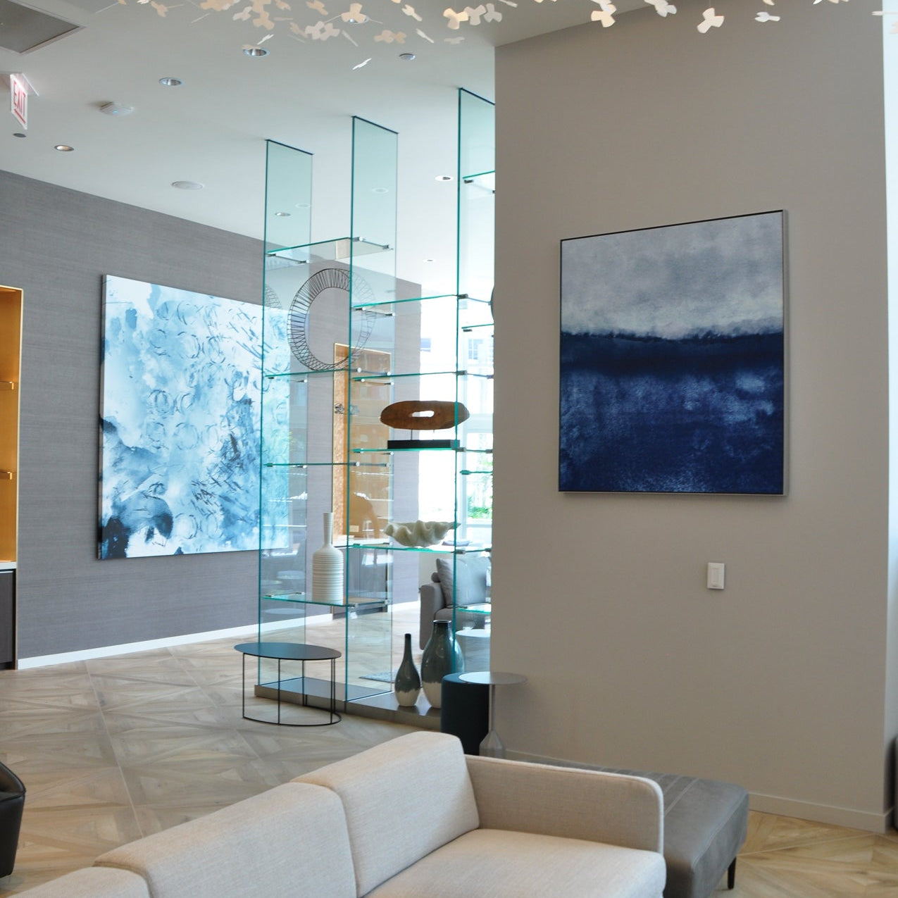 Sophisticated leasing office at 465 North Park adorned with an abstract canvas by WRAPPED Studio, complementing the sleek interior design with a blend of blue hues.
