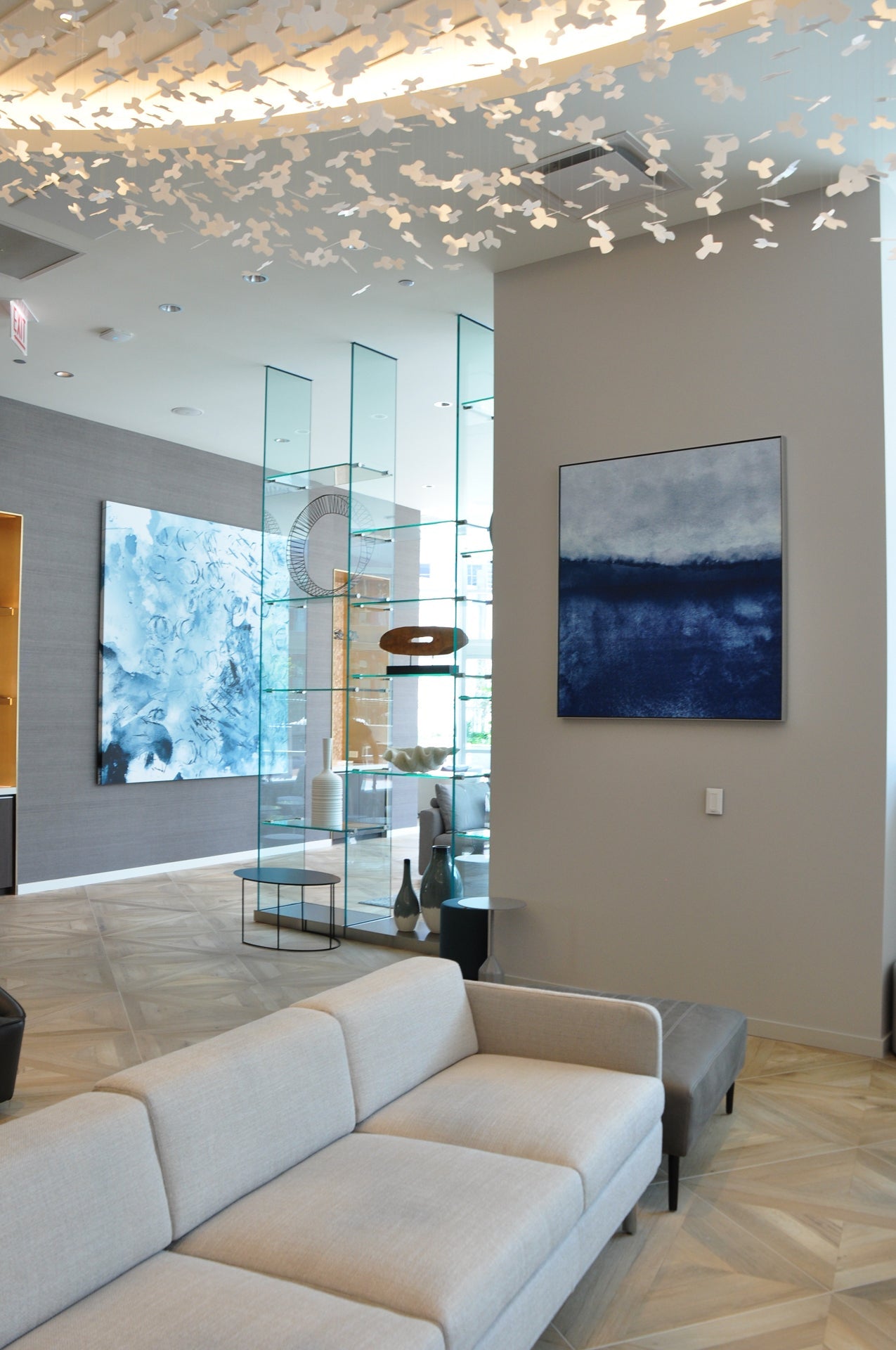 Sophisticated leasing office at 465 North Park adorned with an abstract canvas by WRAPPED Studio, complementing the sleek interior design with a blend of blue hues.
