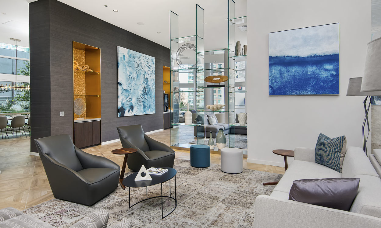 Wrapped Studio’s custom abstract artwork in deep blue tones hangs above a fireplace in a contemporary lounge.