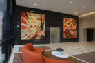 Elegant lobby at 660 Newport Center featuring a pair of large abstract canvases by WRAPPED Studio, offering vibrant energy with warm, intersecting hues.