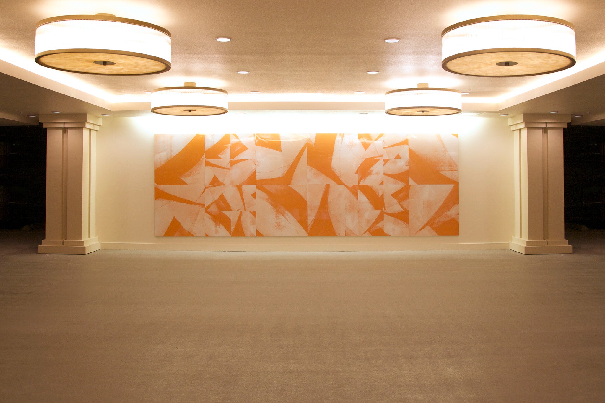 Bold abstract wall installation with angular orange forms on aluminum, created by WRAPPED Studio for Irvine Company’s Centerpointe.