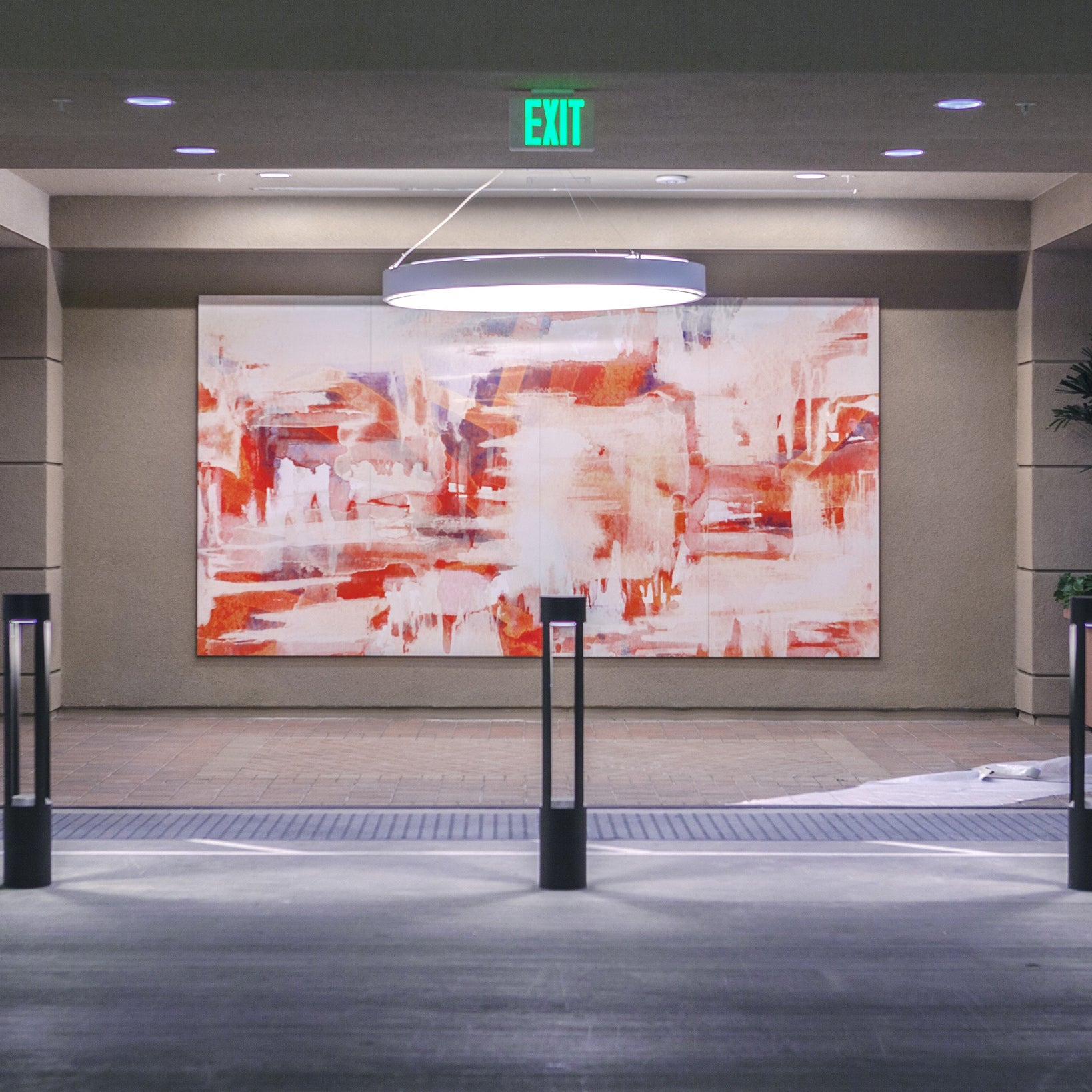 Centerpointe motor court with a captivating abstract painting in red and white hues, under a circular light fixture, combining urban design with artistic flair.