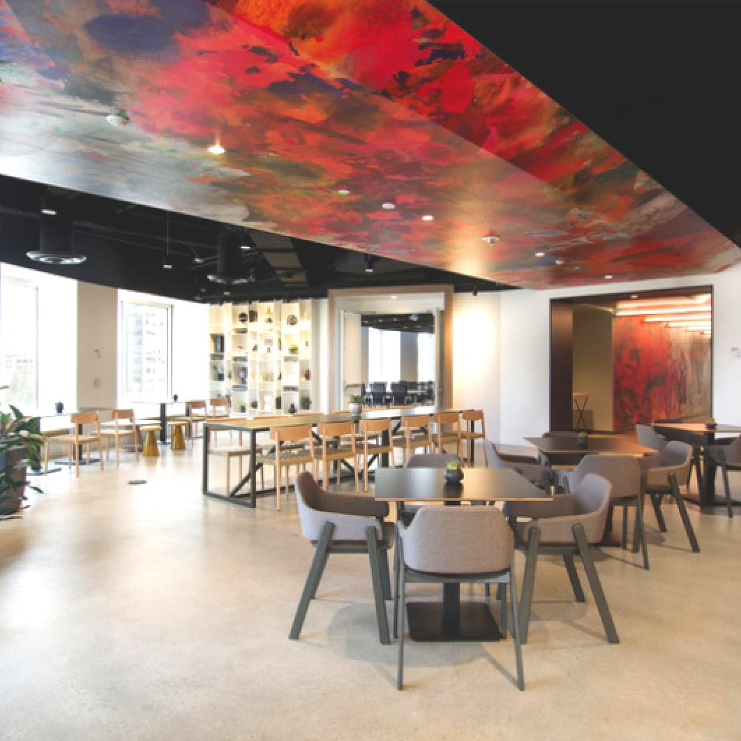 Stylish lounge in Convene DTLA with a blend of abstract ceiling and wall art in vibrant colors, creating a dynamic and inviting co-working atmosphere.