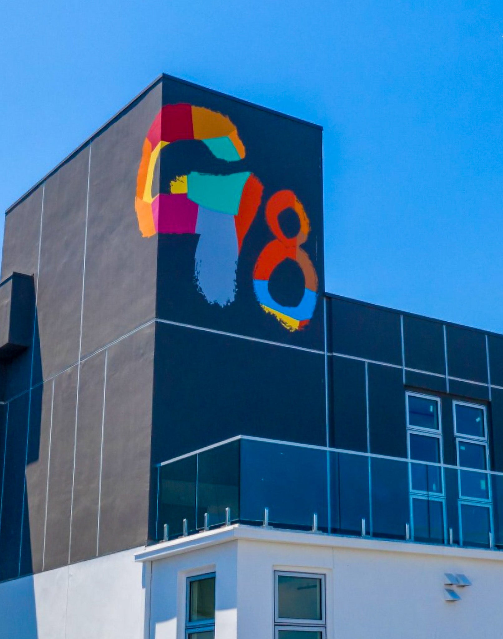 A vibrant hand-painted mural of the G8 logo by WRAPPED Studio on the exterior of G8 apartment homes in Marina Del Rey, California. Commissioned by California Landmark Group, the colorful logo is strategically placed for high visibility, serving as an iconic visual anchor throughout the community.