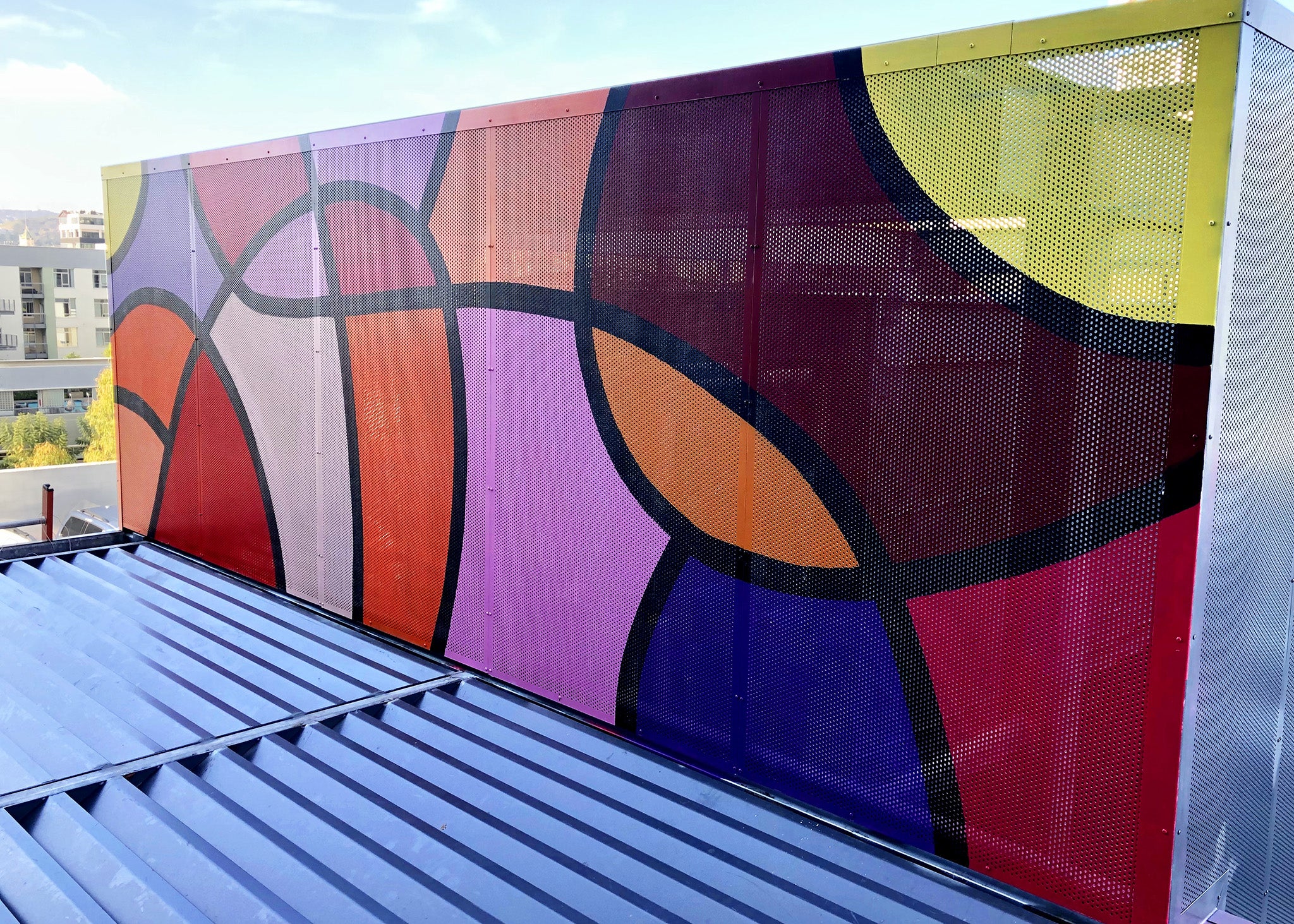 Artistic rooftop installation of an abstract mural with intertwined shapes in dynamic colors, adding a playful touch to the urban skyline.