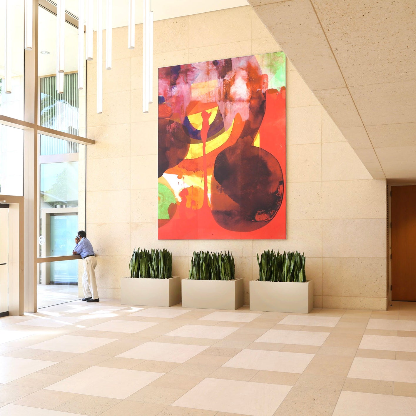 Fiery red and sunset hues adorn a WRAPPED Studio custom canvas, breathing life into the 300 Spectrum Center's lobby with its rich, abstract design.