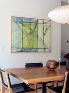 Dining room with wooden table, chairs, and abstract art on the wall. all-groups