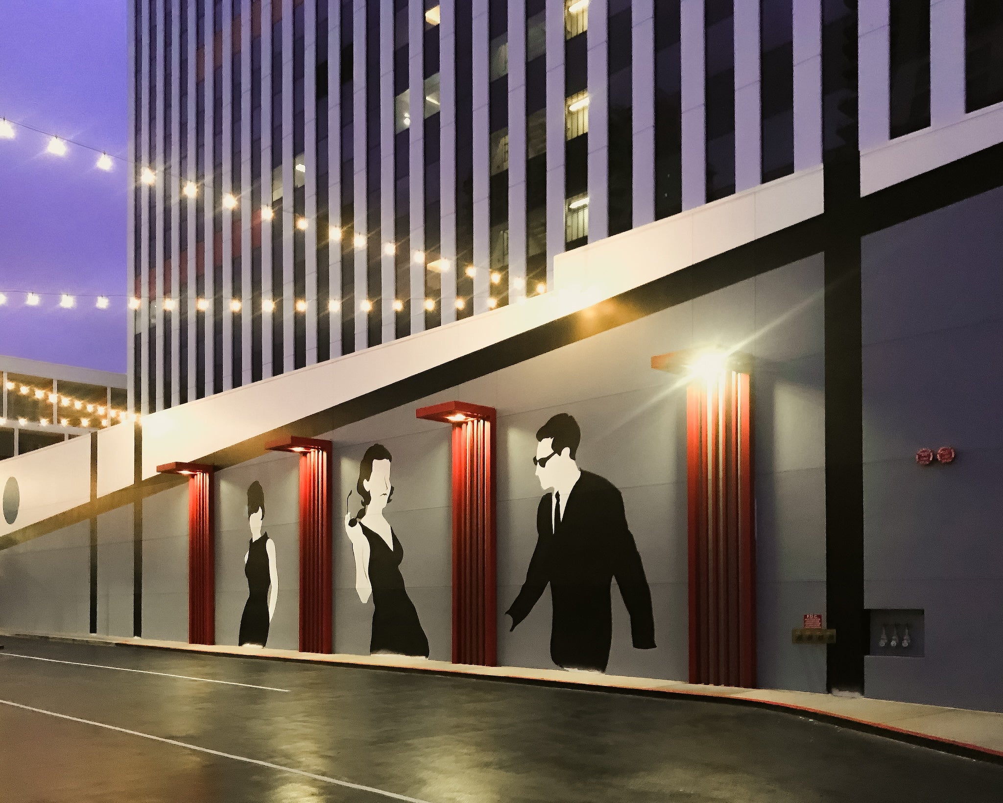 Custom exterior mural designed by WRAPPED Studio for Ensemble HQ, featuring large-scale silhouetted figures in a cinematic composition.