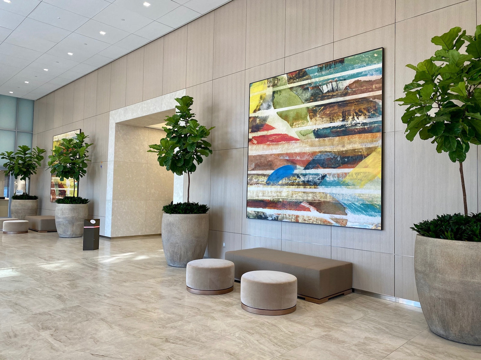 Elegant modern lobby featuring Wrapped Studio's large abstract painting with vibrant stripes